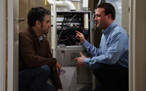 homeowner talking to heating technician about furnace maintenance